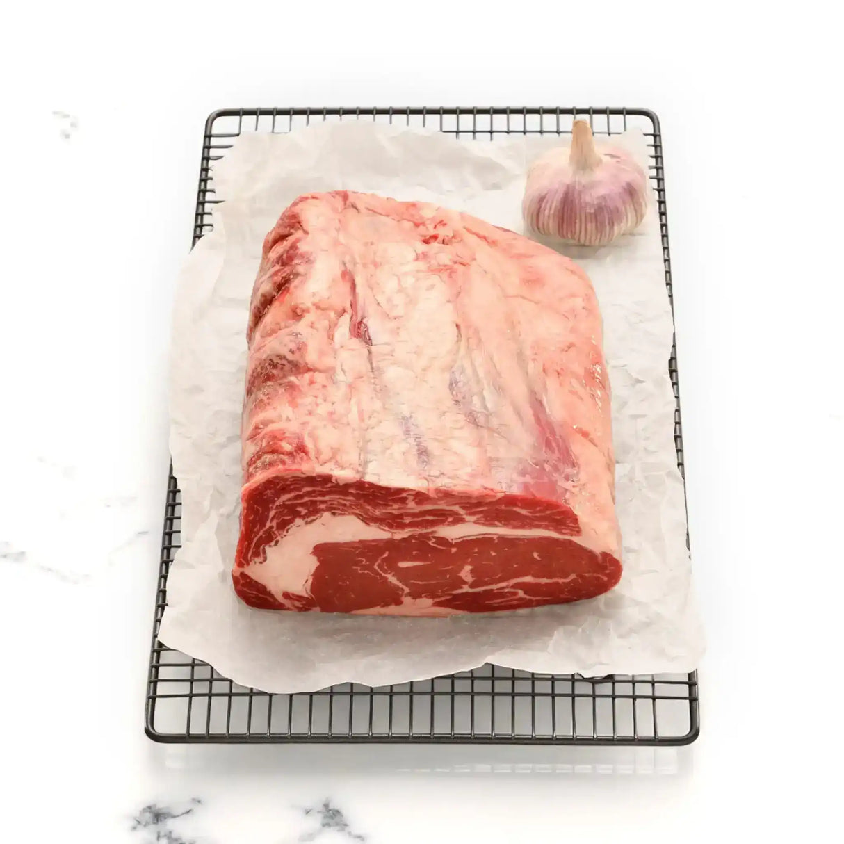 Premium Angus rib fillet steak from Peter Augustus Craft Butcher with garlic on parchment