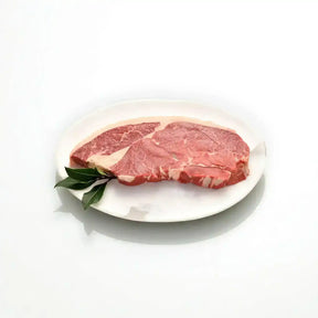 Raw Angus rump steak on a white plate with garnish, fresh Australian beef cut