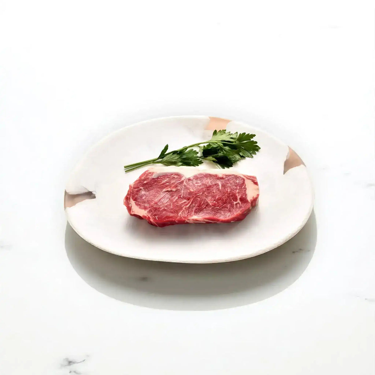 Raw Angus sirloin steak with parsley on a white ceramic plate, gourmet beef cut
