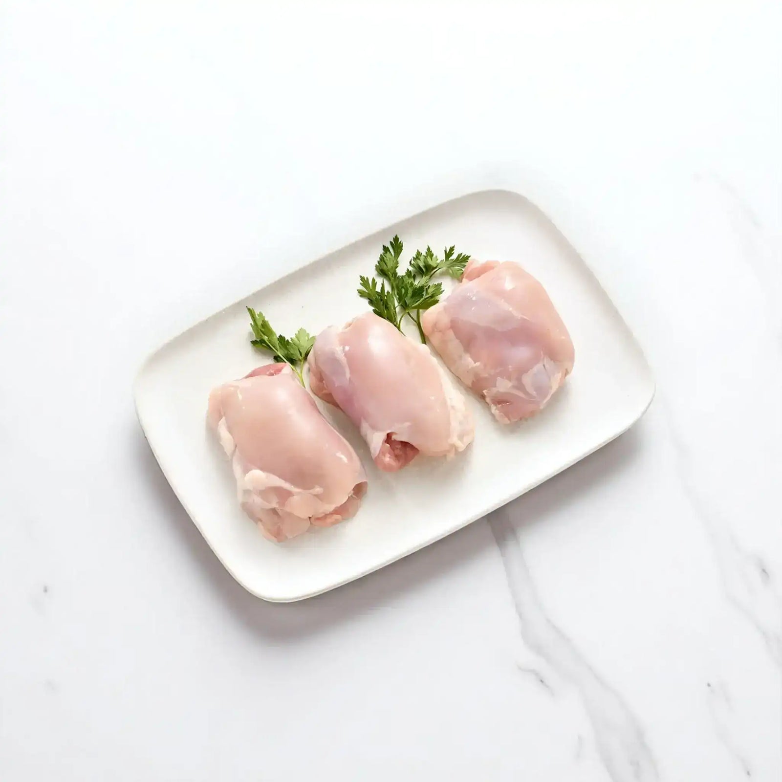 Peter Augustus free-range chicken thigh fillets skin off on platter with parsley garnish