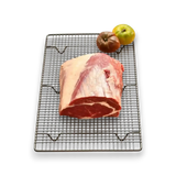 Fresh grass-fed beef roast on cooling rack with heirloom tomatoes, premium Australian butcher quality