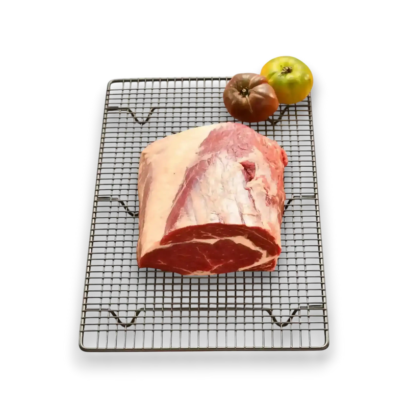 Fresh grass-fed beef roast on cooling rack with heirloom tomatoes, premium Australian butcher quality