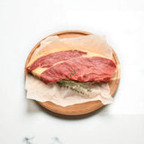 Premium Australian rump steak from Peter Augustus Craft Butcher on a wooden board with herbs