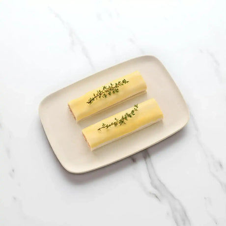 Peter Augustus gourmet sausage rolls topped with fresh herbs on a plate