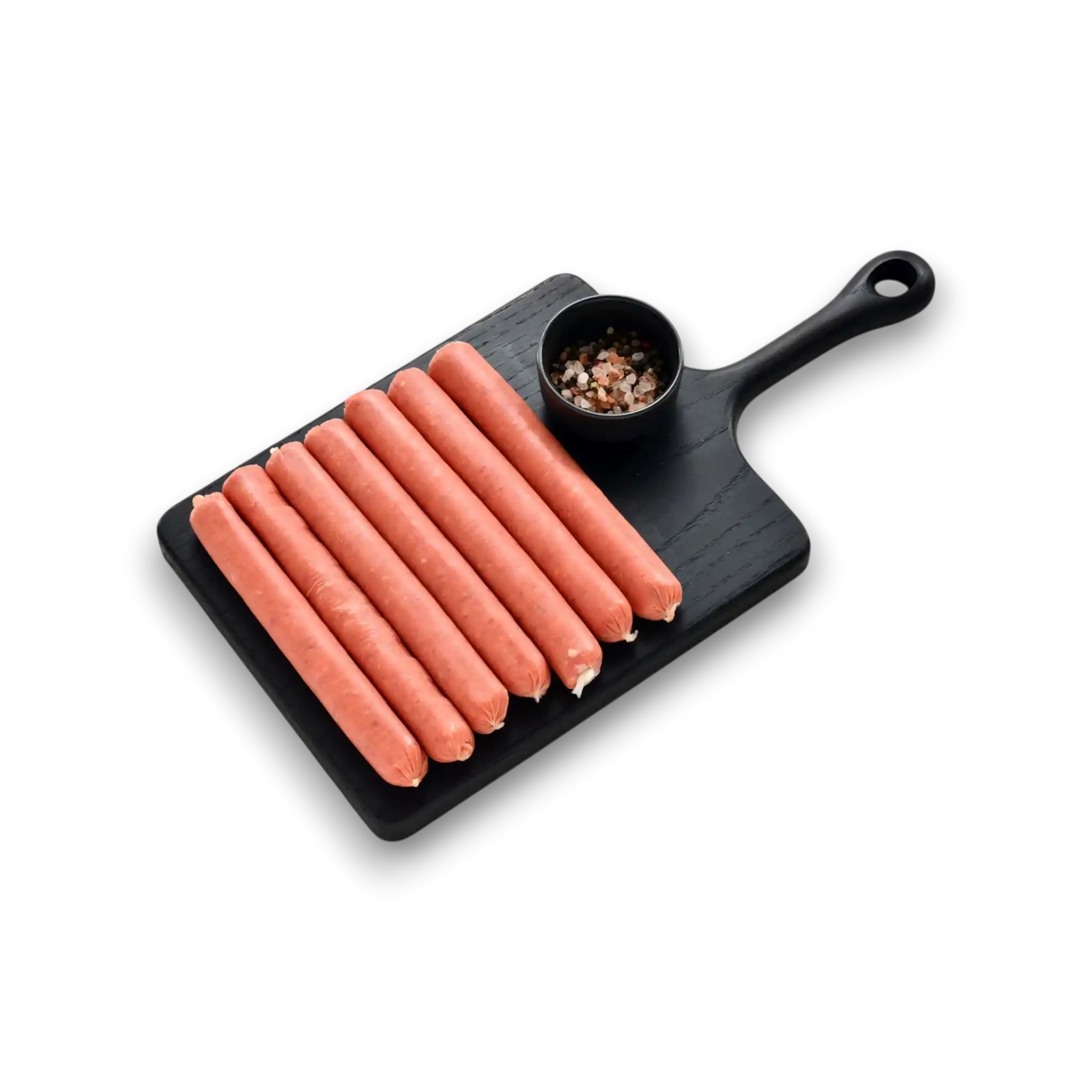 Black cutting board with hot dogs and a small bowl of spices
