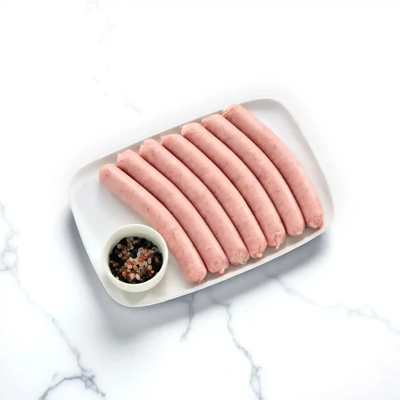 Peter Augustus thin BBQ pork sausages on a white tray with peppercorns