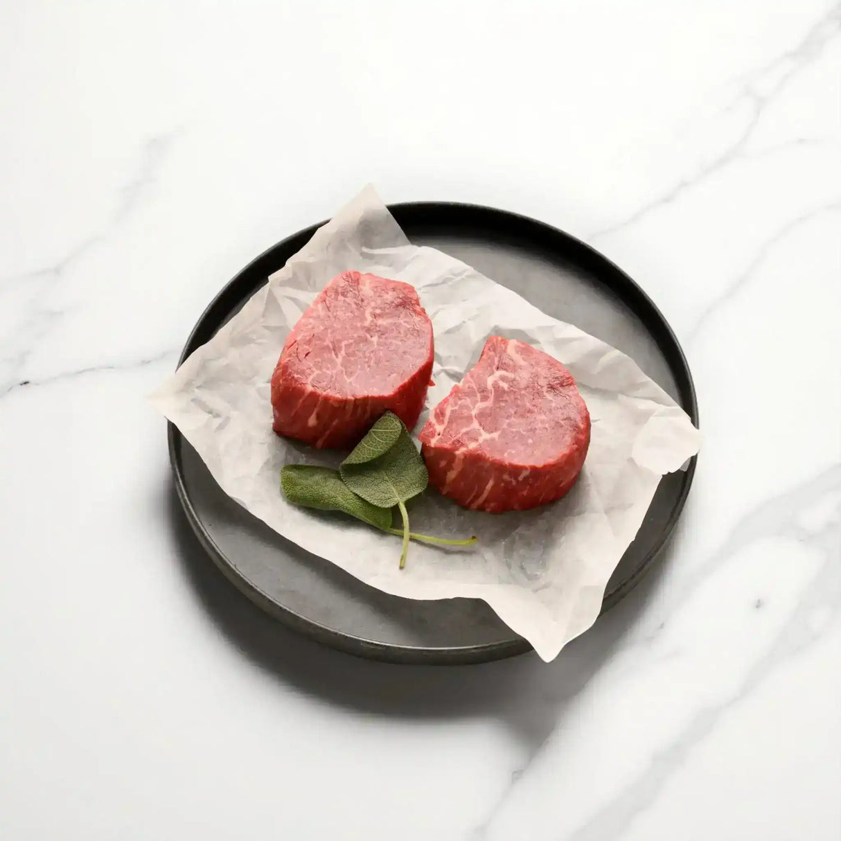 Premium Australian Wagyu eye fillet steaks on parchment with fresh sage, Peter Augustus