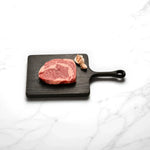 Marbled Wagyu rib fillet steak on wooden board with garlic, Peter Augustus premium Australian beef