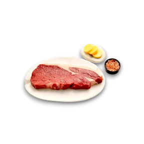 Fresh grass-fed beef steak with butter and Himalayan salt, ready for cooking