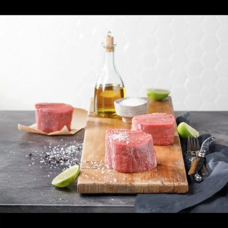 Raw pork medallions on wooden board with olive oil, salt, pepper, and lime, Peter Augustus Craft Butcher