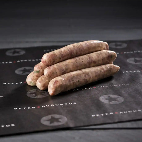 Raw pork sausage stacked on black butcher paper, gourmet sausage product