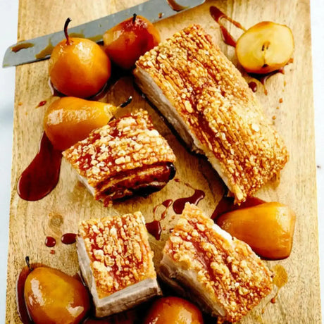 Crispy roast pork belly and glazed pears from Peter Augustus Craft Butcher on a wooden board