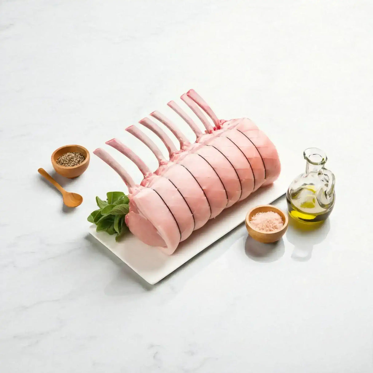 Premium pork rack roast from Peter Augustus Craft Butcher with herbs, oil, and seasoning.