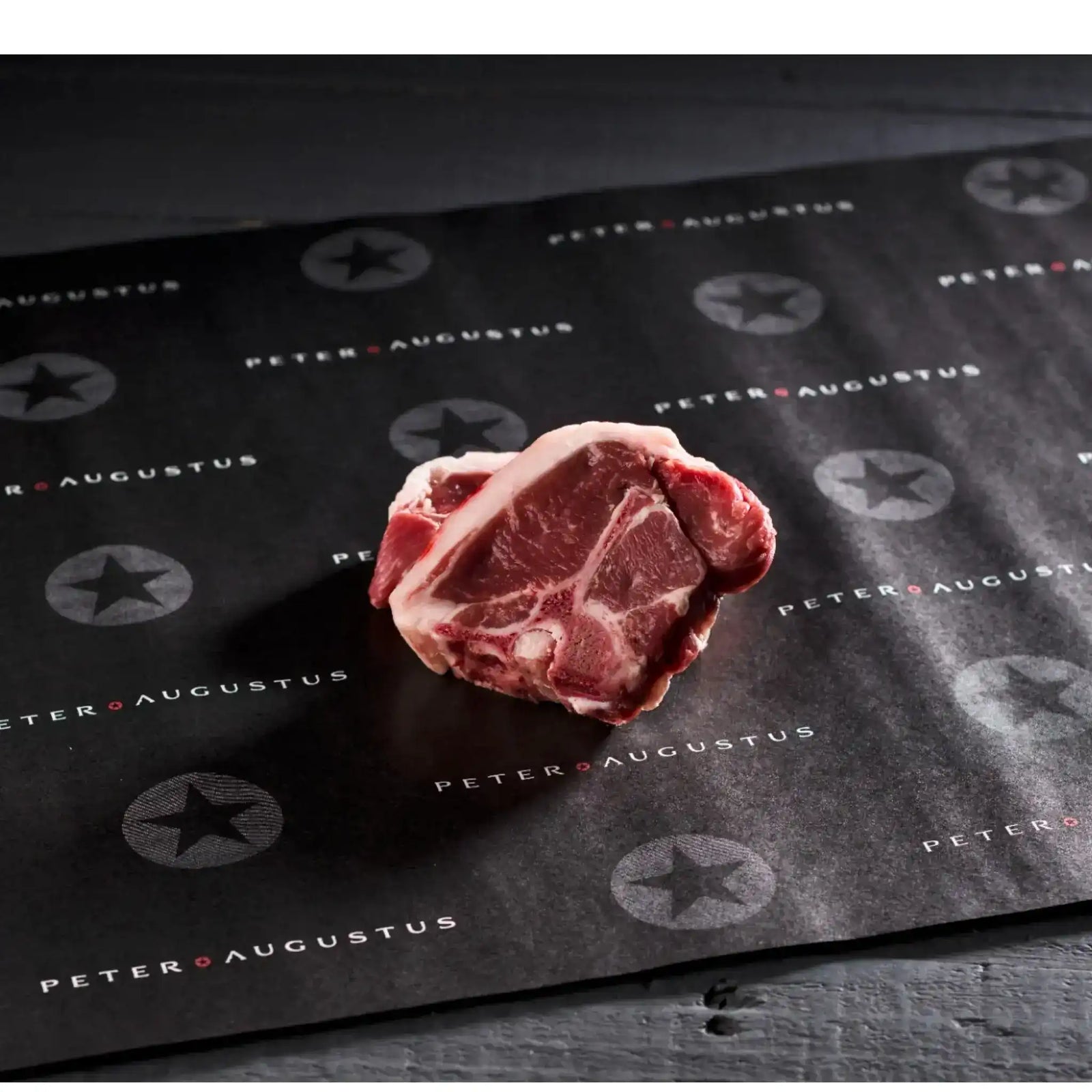 Six Peter Augustus lamb loin chops on wire rack with rosemary and coarse salt