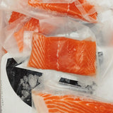 Fresh vacuum-packed salmon fillets on ice, premium seafood delivery