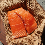 Fresh salmon fillets with marbling on eco-friendly packaging, ready for home delivery