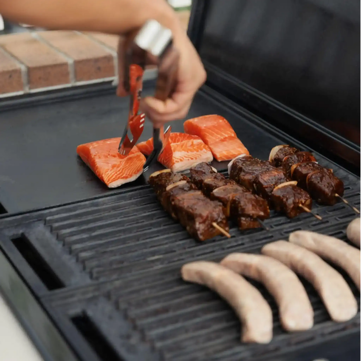 Grilling fresh salmon fillets, marinated beef skewers, and gourmet sausages on a BBQ