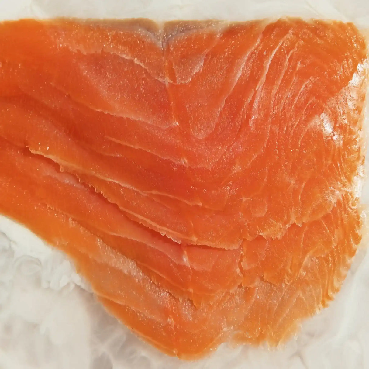 Raw sliced salmon fillet on parchment, fresh seafood with vibrant orange color