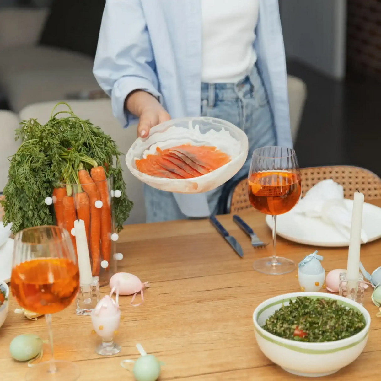 Fresh salmon slices served on a plate at a festive dinner table with wine and vegetables