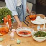 Sliced smoked salmon on a table with salads, carrots, wine glasses, and festive decor.