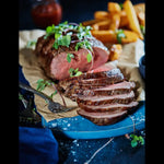 Sliced roast beef garnished with fresh herbs, served with golden potato wedges, Peter Augustus