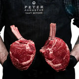 Butcher holding two premium Angus standing rib roasts from Peter Augustus Craft Butcher