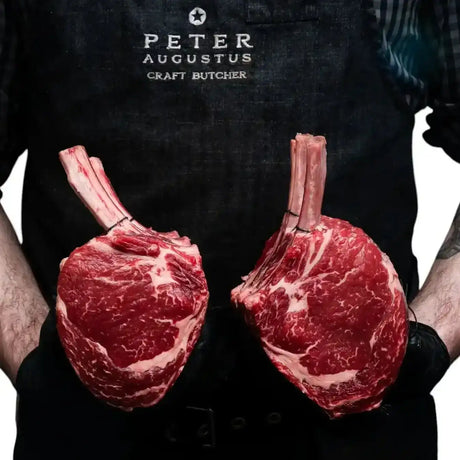 Butcher holding two premium Angus standing rib roasts from Peter Augustus Craft Butcher