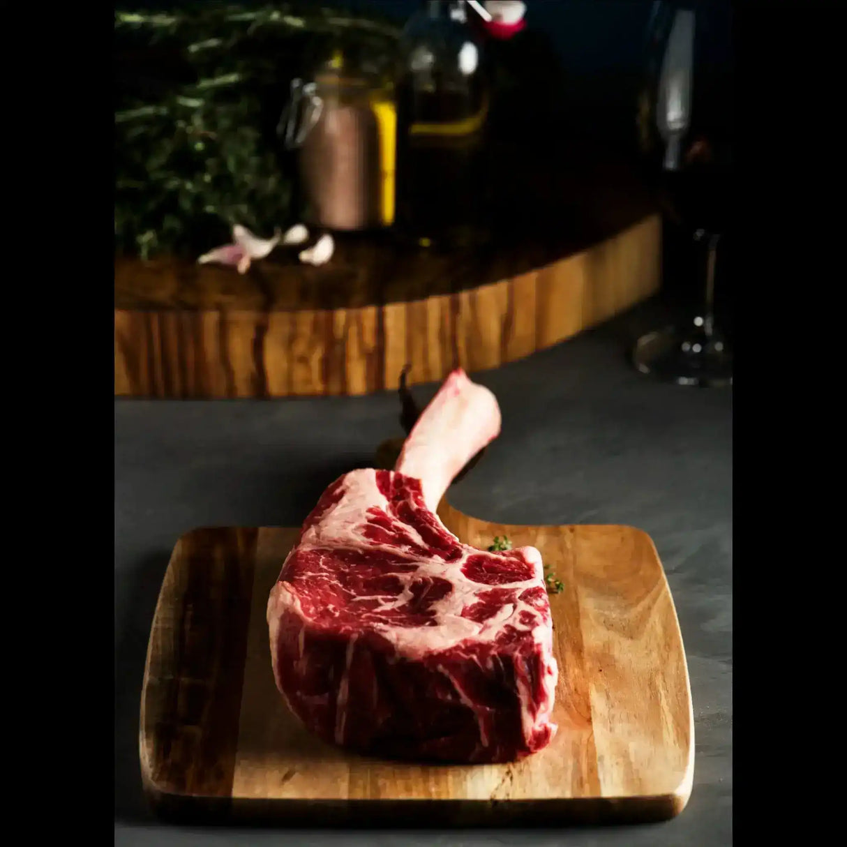 Raw tomahawk steak with rich marbling on wooden board, gourmet beef cut