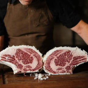 Craft butcher displaying premium marbled Australian beef Tomahawk dipped in tallow at Peter Augustus