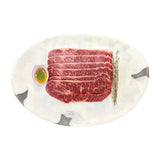 Premium Wagyu beef slices with marbling, served on marble platter with herb garnish and egg yolk