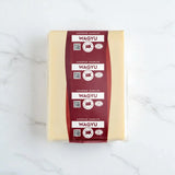 Block of Wagyu beef tallow with maroon superior marbled Wagyu labels on a white marble surface