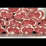 Stacked Australian Wagyu cube roll steaks with rich marbling on a butcher's counter