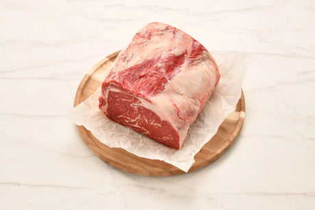 Marbled Wagyu rib fillet piece on parchment paper and wooden board