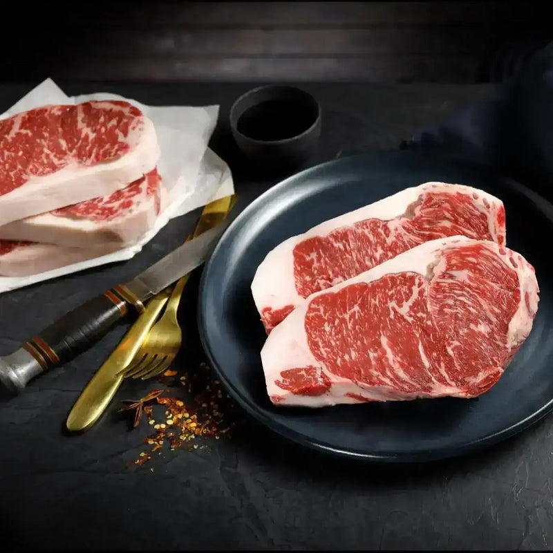 Premium Australian Wagyu striploin steaks with rich marbling on a dark plate, Peter Augustus