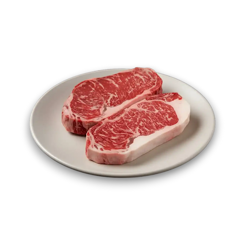 Two premium marbled beef steaks on a white plate, showcasing rich Wagyu or Angus quality