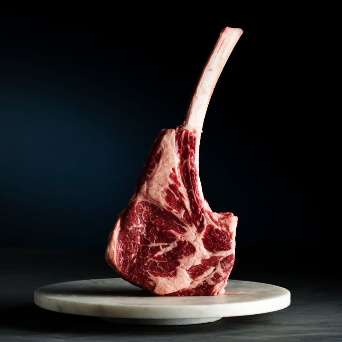 Raw Wagyu Tomahawk steak on a marble slab plate